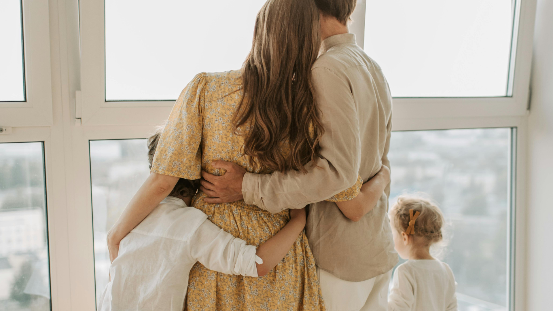 A family embracing by a sunlit window — the kind of moment a strong life insurance plan helps protect.